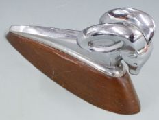 Dodge ram 1950's car mascot or hood ornament, on wooden display base, length 23.5cm
