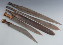 Five 19thC African tribal machetes and short swords including one with a turned wooden handle and