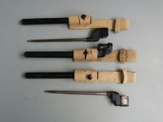 Two British No4 Mk2 bayonets together with an Mk3 example, all with 20cm spike blades, scabbards and