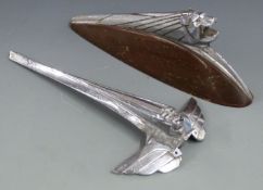 Peugeot lion car mascot on wooden display base, length 27cm, together with a similar Lion mascot,