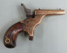 Deactivated percussion hammer action .22 pocket or muff pistol with brass body, shaped mahogany