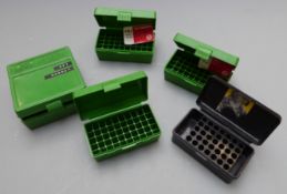 Five hard rifle cartridge cases.