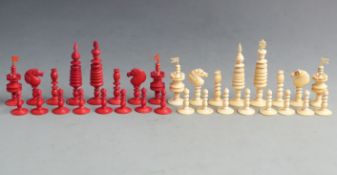 A 19thC turned ivory chess set with one side stained red, height of king 13cm.