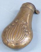Copper and brass pistol or revolver powder flask with embossed decoration to both sides, 19cm long.