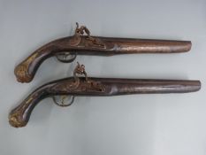 A pair of flintlock hammer action pistols with brass wire inlaid decoration, embossed brass