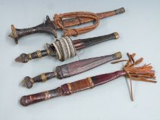 Four African tribal daggers, each with leather scabbard and shaped handle, longest 31cm