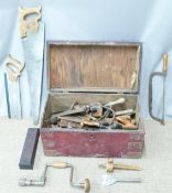 A metal bound trunk containing vintage tools including woodworking saws, Marsden Brothers saw, bit