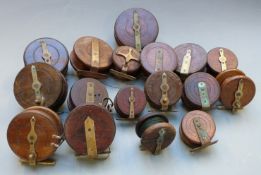 Seventeem vintage wooden and brass fishing reels, largest diameter 12cm
