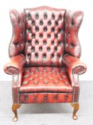 Chesterfield wing back armchair raised on front cabriole legs and swept rear legs, H112cm