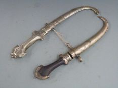 Two white metal Moroccan or similar jambiya daggers both with engraved decoration, one with a wooden