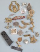 A small collection of military cap badges including Long Range Desert Group and Loyal Suffolk