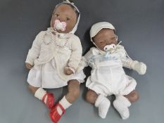 Two Ashton Drake Galleries Reborn silicone dolls one with closed mouth, blue eyes and black hair,