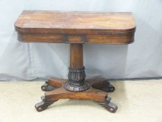 19thC rosewood fold over card table raised on a turned support and quatrefoil base with scrolling