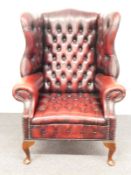 Chesterfield wing back armchair raised on front cabriole legs and swept rear legs, H112cm
