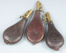 Three leather and brass shot flasks, two G & J W Hawksley with embossed shooting scenes the other