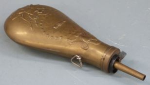 Brass powder flask with embossed decoration and 'US' shield to both sides, 23.5cm long.