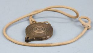 Brass percussion cap dispenser, 8.5cm long, on braided cord.