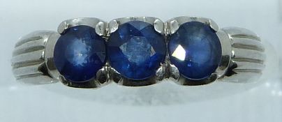 A white metal ring marked 900 set with three round cut sapphires, 6.6g, size N/O