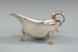 George VI hallmarked silver sauce boat with shaped edge and raised on three pad feet, Birmingham