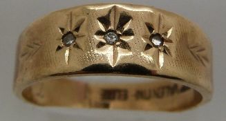 A 9ct gold ring set with three diamonds in star settings, 3.6g, size O