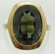 A yellow metal ring marked 333 set with an oval cut diopside, 4.3g, size M