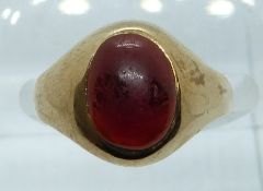 A 9ct gold ring set with a garnet cabochon, 2.4g, size J