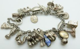 A silver charm bracelet with over 22 charms including elephant, mounted jockey on horse, cow, etc