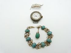 A silver watch, silver brooch and scarab beetle bracelet