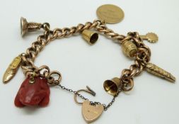 A 9ct gold charm bracelet set with mainly 9ct gold charms including whistle, intaglio fob and