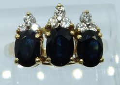 An 18ct gold ring set with three oval cut sapphires and diamonds, 6.6g, size K