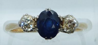 An 18ct gold ring set with an oval cut sapphire of approximately 0.65ct and diamonds each approx 0.