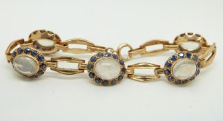 A yellow metal bracelet marked 14k gold set with five moonstone cabochons, each surrounded by