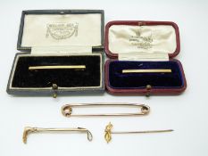 A 9ct gold riding crop brooch, two 9ct gold bar brooches, 9ct gold stick pin (7.3g), yellow metal