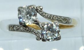 An 18ct gold ring set with two old cut diamonds, each approximately 0.35ct, and with diamond