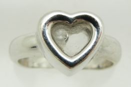 An 18ct white gold ring in the form of a heart set with a loose diamond, 7.8g, size N
