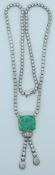 An 18ct white gold necklace set with round cut diamonds and an emerald cut natural Colombian emerald