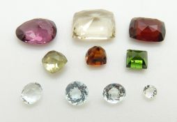 A collection of loose stones including three round cut aquamarines, feldspar, garnet, etc