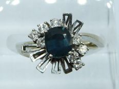 A white gold ring marked 14k set with a sapphire and diamonds, 4.5g, size J