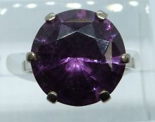 An 18ct white gold ring set with a round cut synthetic purple sapphire, 7.7g, size J/K