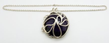 A large oval cut amethyst (175ct) set into a silver floral pendant setting, on silver chain