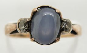 A yellow metal ring set with a star sapphire cabochon and two diamonds, 2.1g, size K