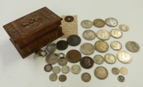 A small Black Forest carved casket containing a collection of coinage including silver and two