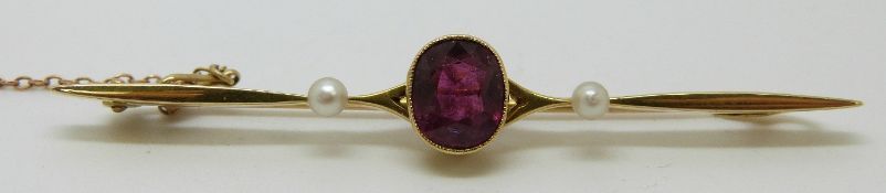 A 15ct gold brooch set with a garnet and pearls (4g), in original box