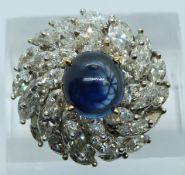 A white metal ring set with a sapphire cabochon measuring 3.17ct surrounded by marquise cut