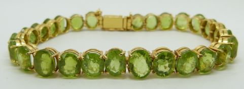 A yellow metal bracelet set with oval peridot, 23.4g