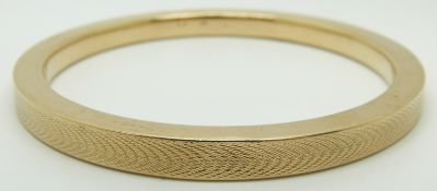 A 9ct gold flapper bangle with engine turned decoration, 18.8g