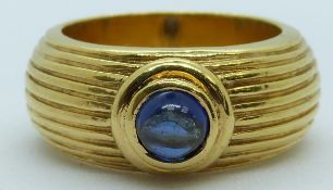 An 18ct gold textured ring set with a sapphire cabochon, 11.1g, size L