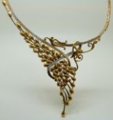A 21ct gold diamond set necklace with pierced links and garland decoration, 46g