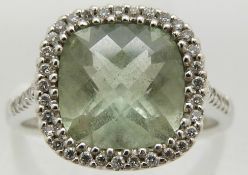 An 18ct white gold ring set with a mixed cut aquamarine surrounded by diamonds, 4.6g, size M