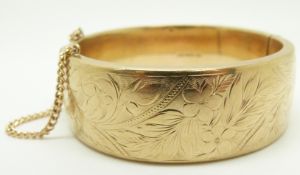 A 9ct gold bangle with engraved decoration, 36.2g